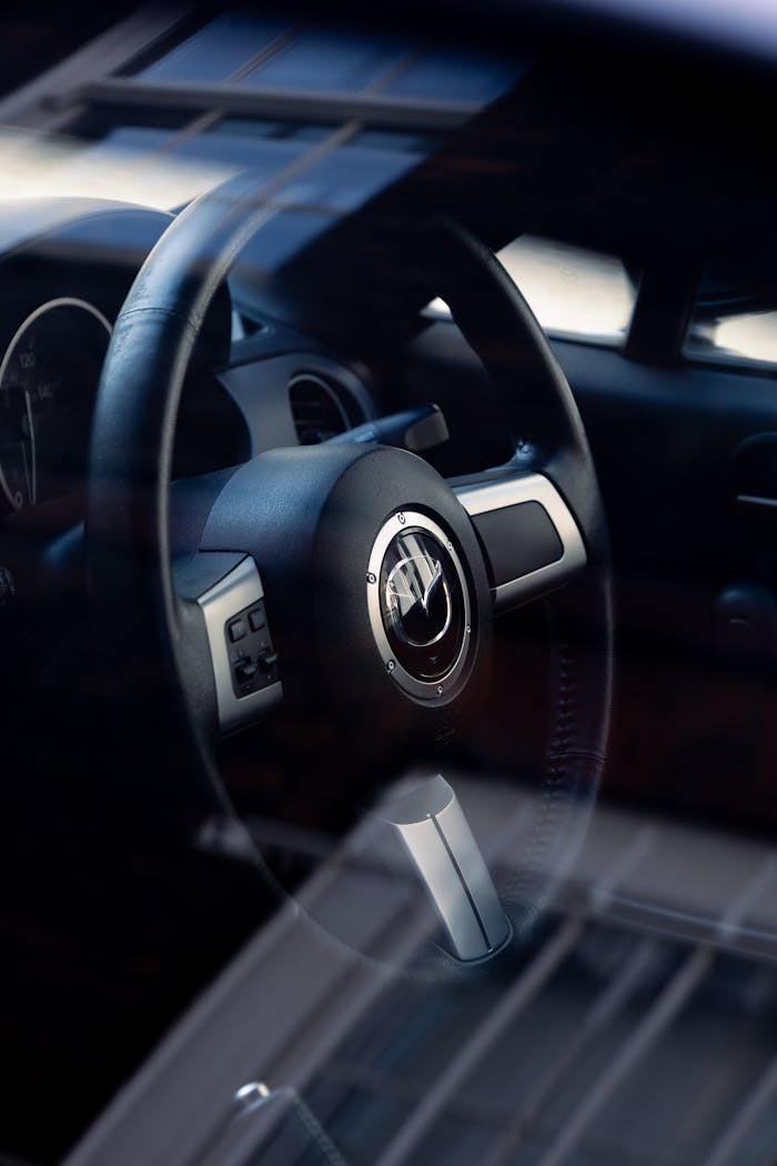 Close-up of a car steering wheel through the window showcasing a sleek interior design.